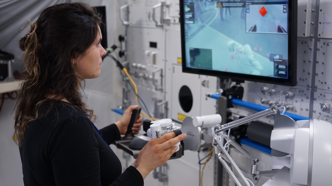 A researcher tele-operating a robot from a space station mockup